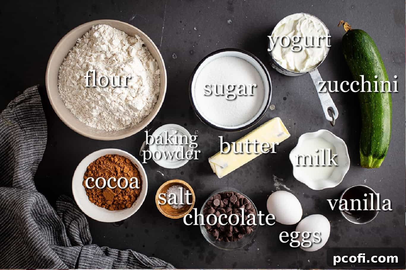 Ingredients for making chocolate zucchini muffins, with text labels.