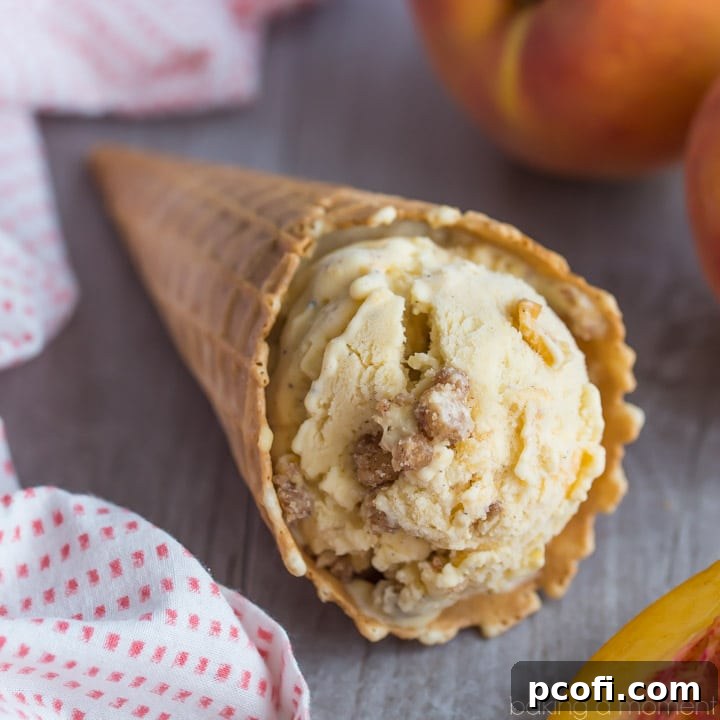 Brown Butter Peach Crumble Ice Cream - The ice cream features a brown butter base with chunks of juicy peaches and a delightful cinnamon streusel swirl.