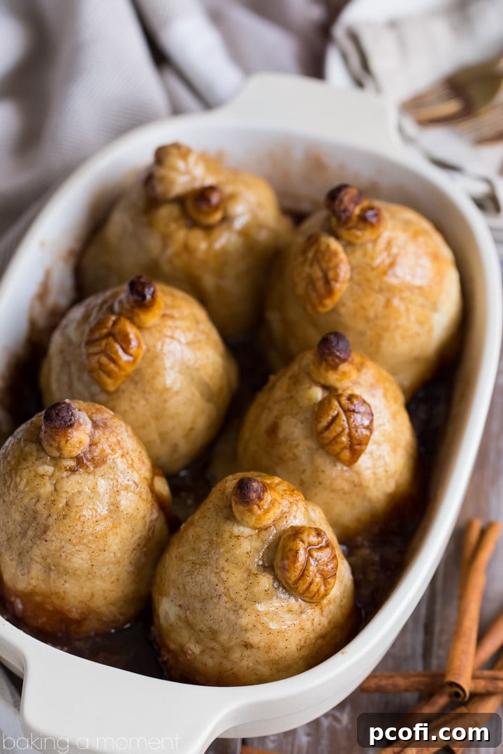 Individual pear dumplings baked to golden perfection, bathed in a shimmering cinnamon sauce, ready to be served.
