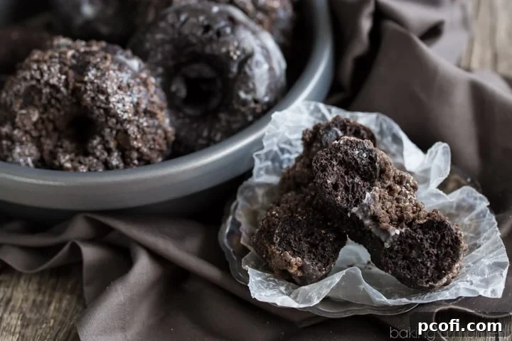 Versatile baked chocolate donuts: Enjoy them plain, with a sweet vanilla glaze, or topped with a scrumptious chocolate crumb for varied indulgence.