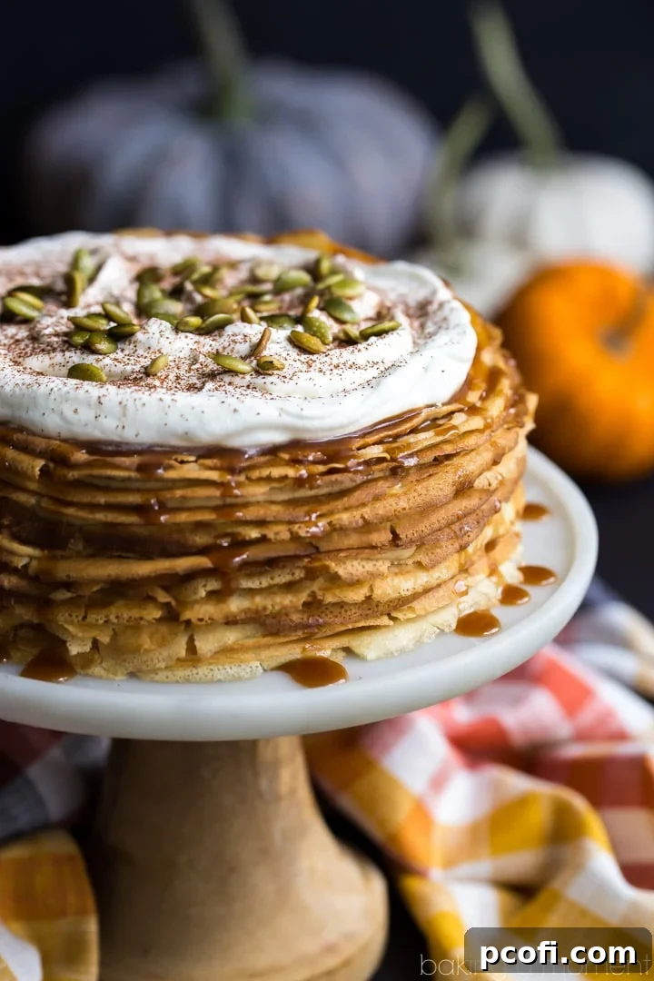 Pumpkin Crepe Cake showing its impressive height and layers, garnished with whipped cream and caramel, ready for a special occasion.