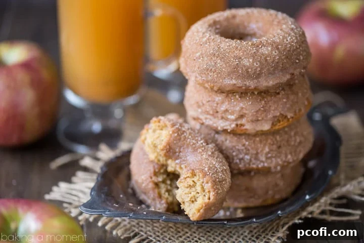 Baked apple cider donuts arranged on a rustic wooden board, ready to be enjoyed.