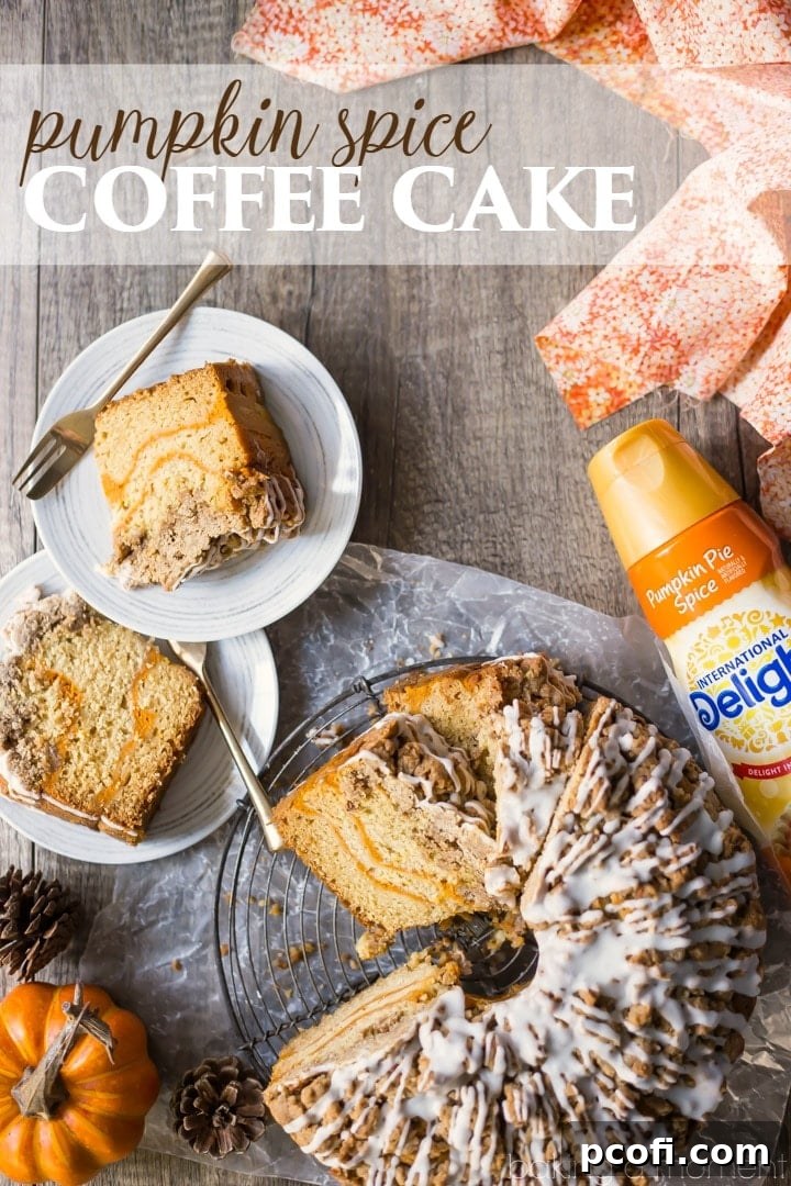 Close-up of a slice of Pumpkin Spice Coffee Cake, showing the moist interior, pumpkin swirl, and crumb topping.