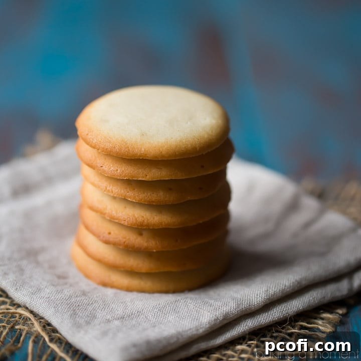 Homemade Brown Edge Wafers piled on a cooling rack, showing their golden brown edges and delicate texture