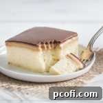 A slice of homemade Peanut Butter Tandy Cake revealing layers of tender cake, creamy peanut butter, and chocolate ganache.