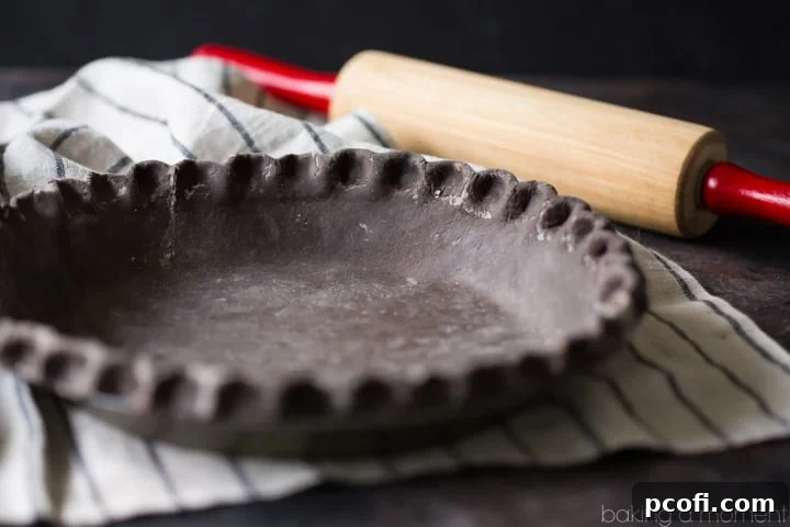 Homemade chocolate pie crust ready for baking, showcasing the beautiful folds that promise a super flaky texture. A baker's delight.