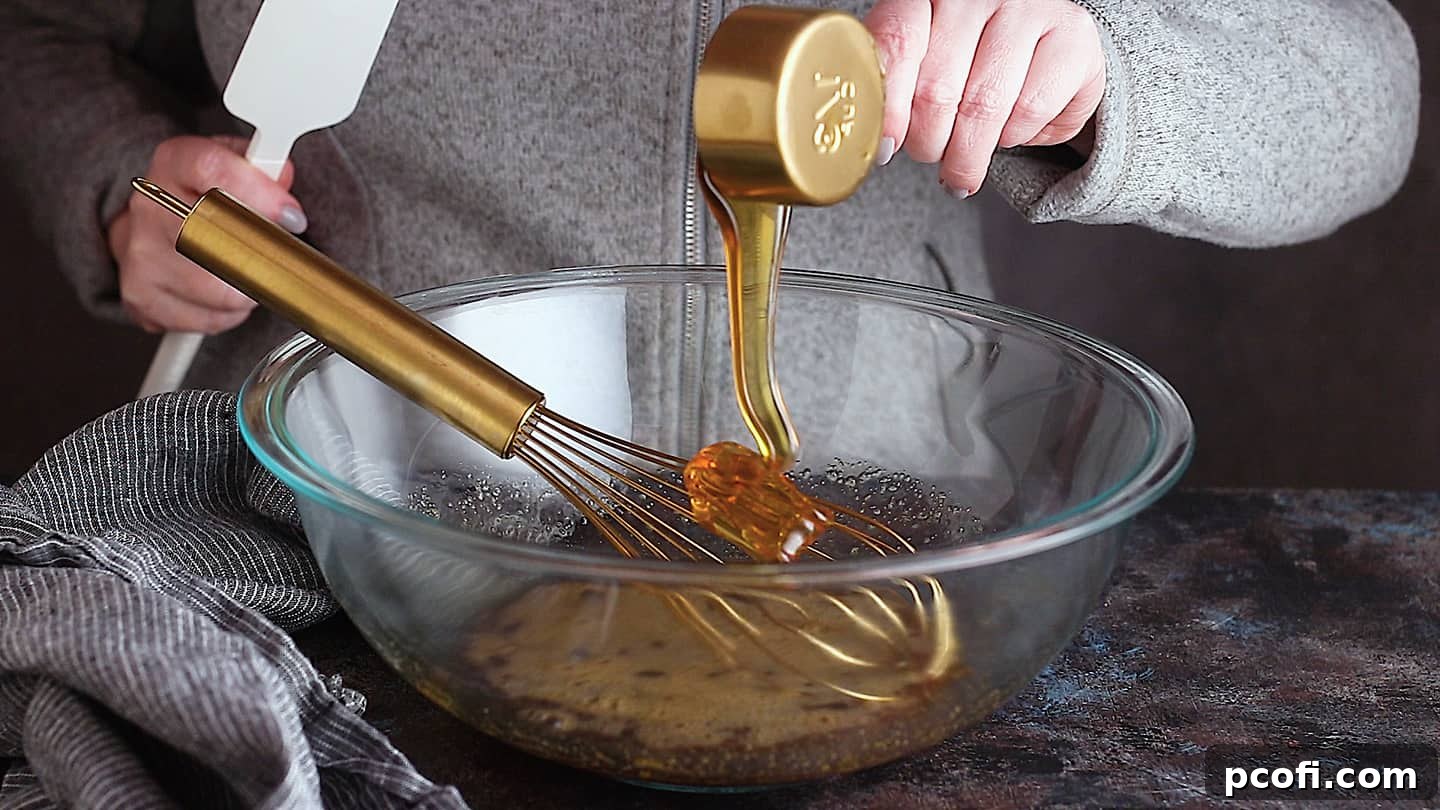 Adding honey, a natural sweetener, to the whisked eggs and brown sugar for a rich, corn-syrup-free chocolate pecan pie filling.
