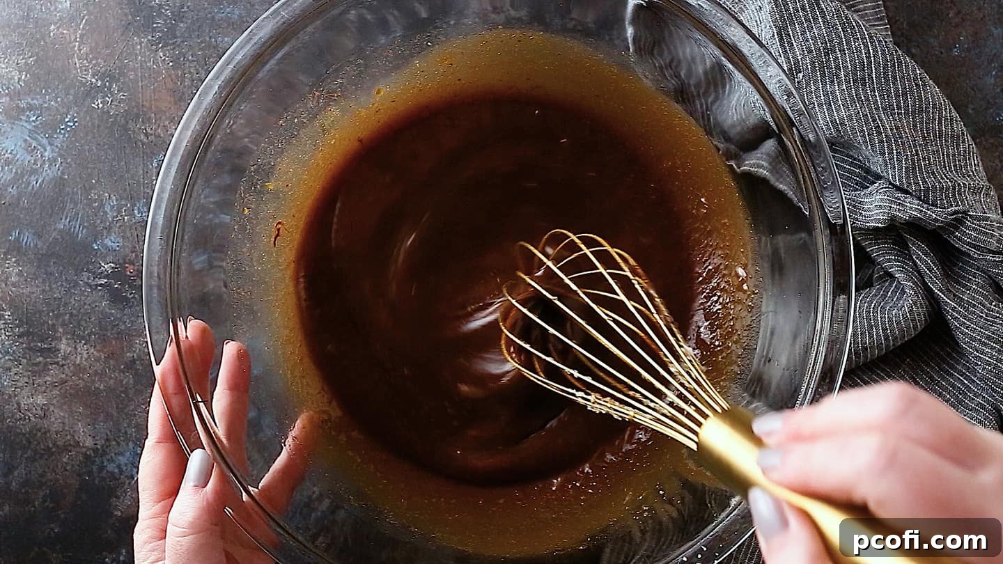 Thoroughly whisking all wet ingredients for the chocolate pecan pie filling, including melted chocolate, butter, and optional bourbon, to achieve a smooth, uniform mixture.