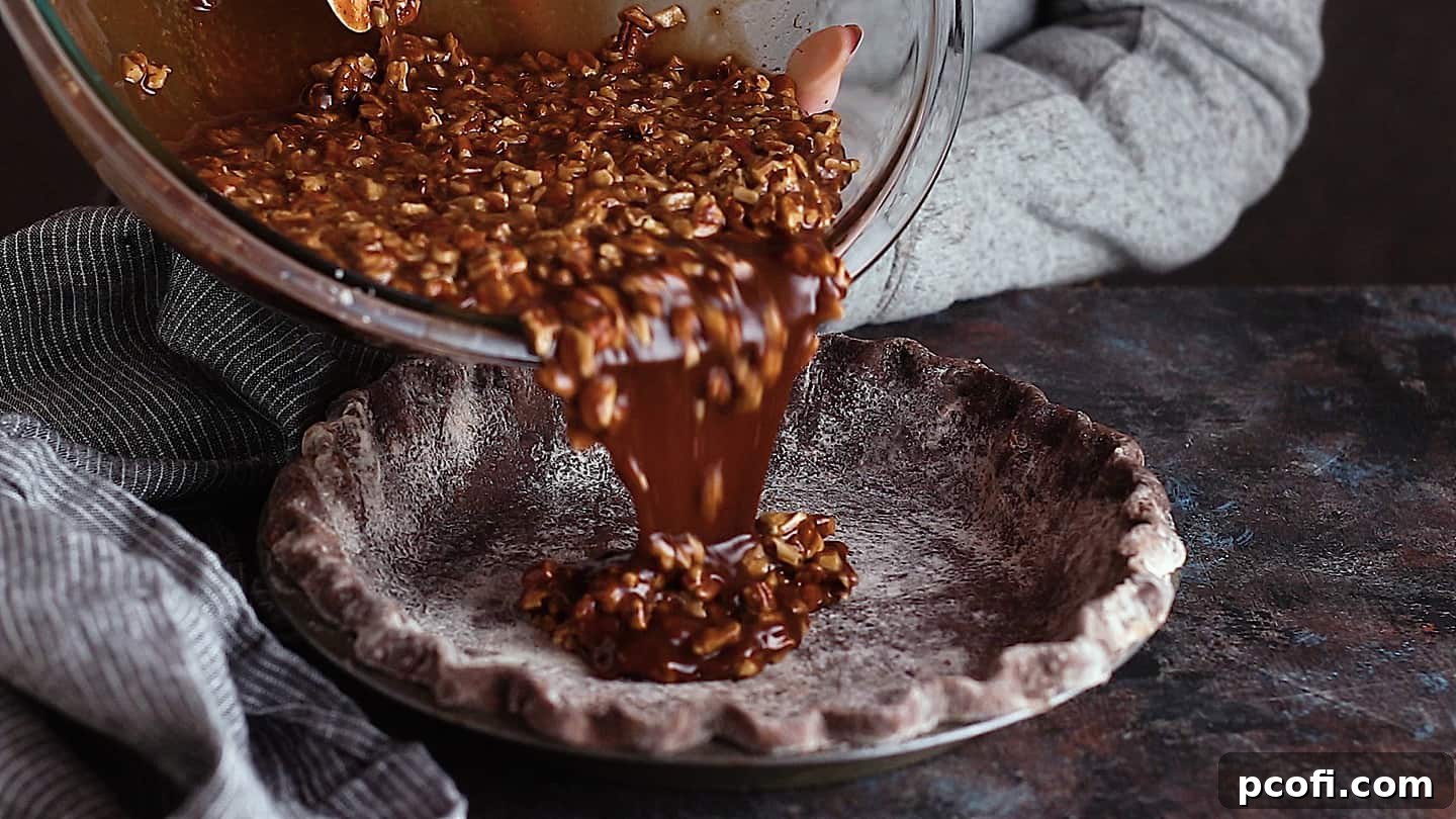 Pouring the luscious chocolate pecan pie filling, studded with pecan pieces, into a perfectly prepared chocolate pie crust.