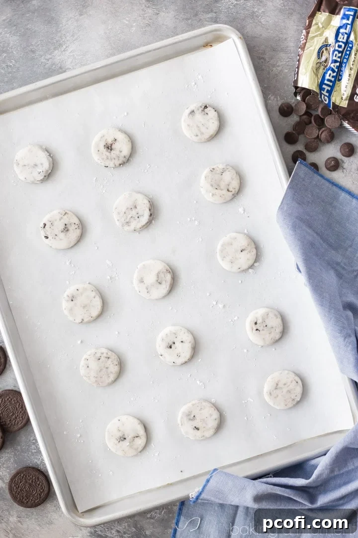 A top-down view of several finished cookies and cream peppermint patties arranged artfully, highlighting the crushed Oreo pieces within the mint filling.