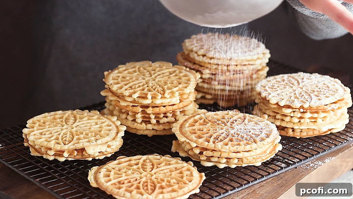 Dusting pizzelle cookies with powdered sugar.