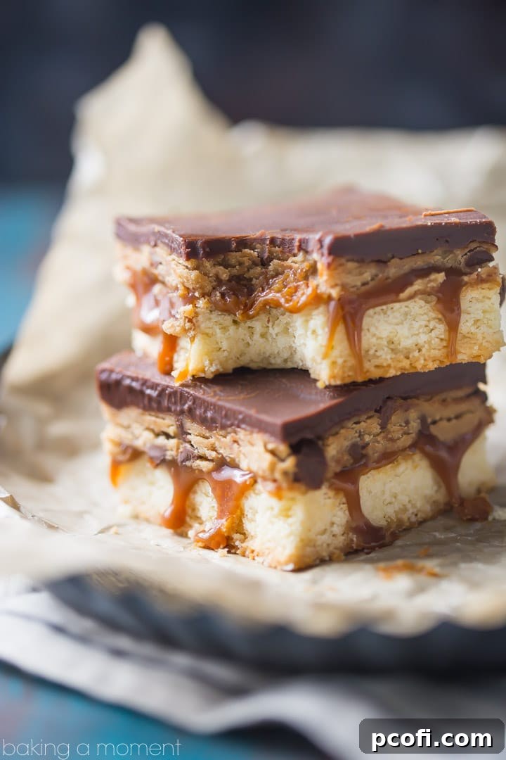 A slice of Peanut Butter Cookie Dough Billionaire Bar showing the four distinct layers clearly.