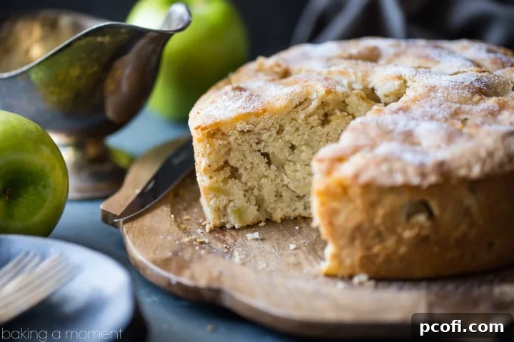 A slice of Irish Apple Cake topped with creamy whiskey hard sauce, ready to be enjoyed.