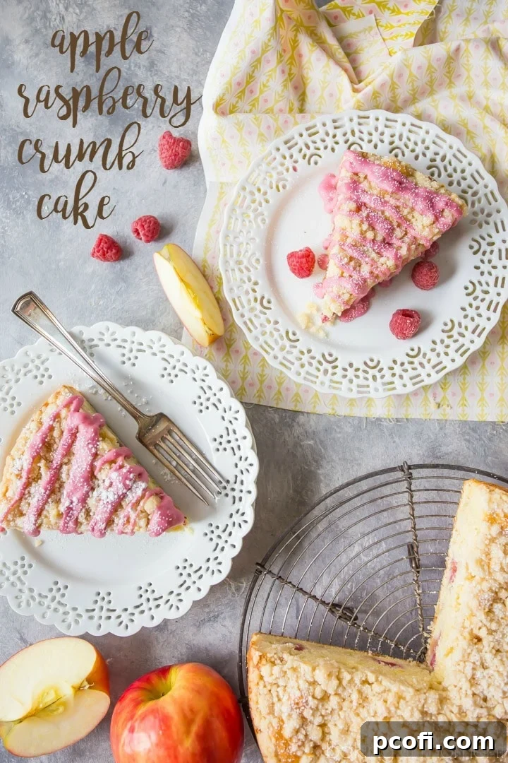 Close-up of the Apple Raspberry Crumb Cake, highlighting the delicate pink glaze, fluffy cake, and fruit distribution. Perfect for a special occasion like Mother's Day.