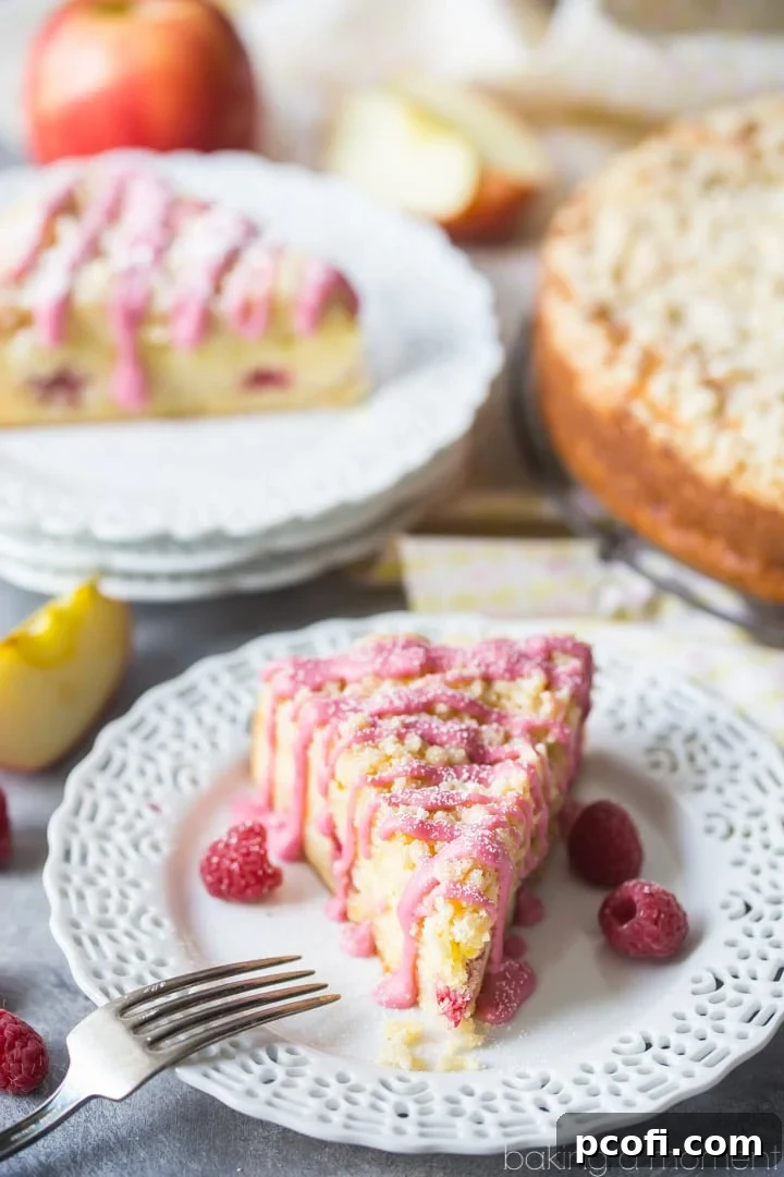 A close-up overhead shot of the Apple Raspberry Crumb Cake, showing the generous crumb topping and subtle pink glaze. Ready to be served for a special breakfast or gathering.