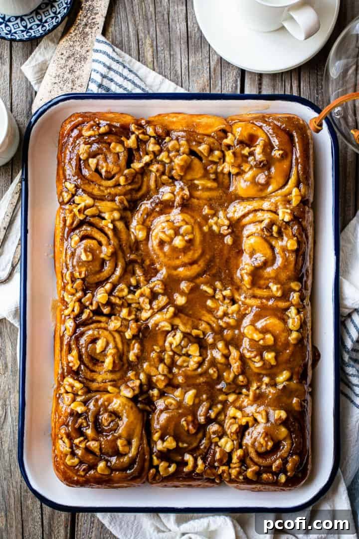 Overhead image of pecan sticky buns on a distressed wooden table.