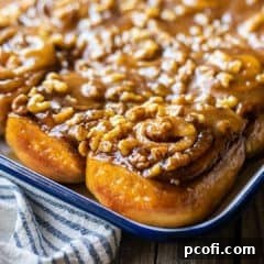 Fresh baked sticky buns on a white enamel serving tray with blue trim.