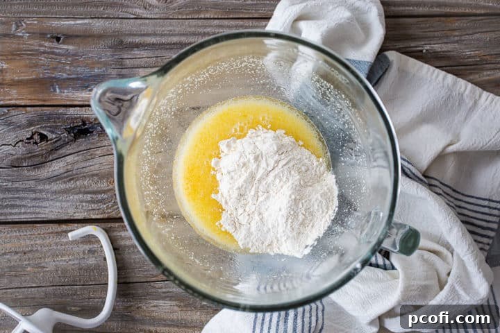 Adding flour to sticky bun dough.