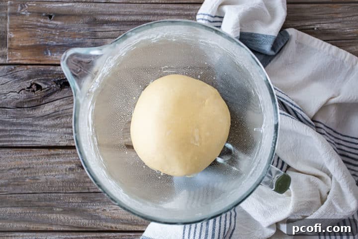 Allowing sticky bun dough to rise in an oiled bowl.