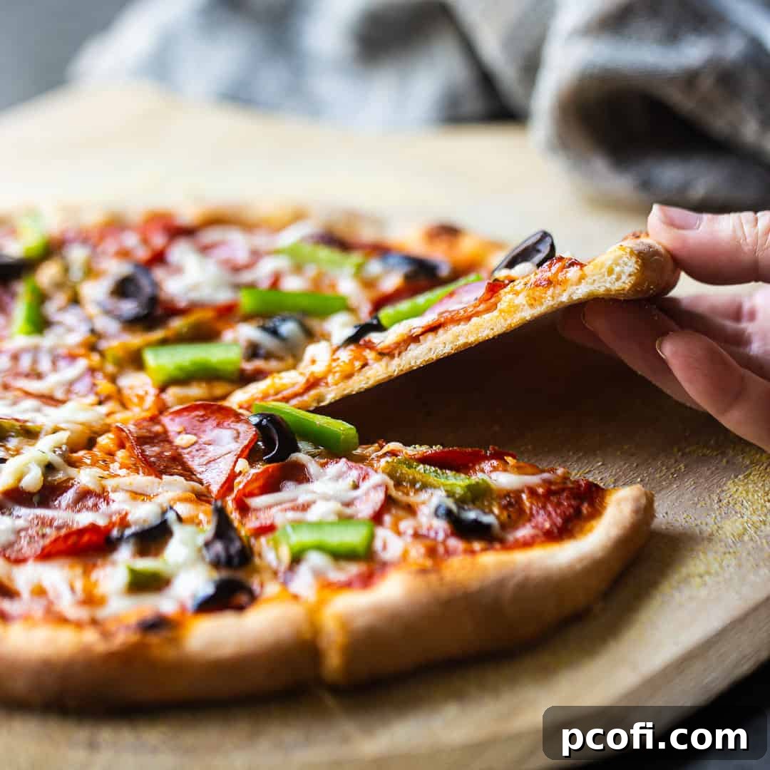 Freshly baked homemade pizza dough, sliced to reveal its perfect, crispy crust, ready for your favorite toppings.