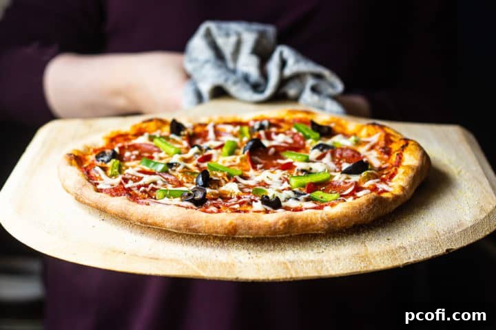 Quick and easy pizza dough recipe, baked to golden perfection and served on a wooden pizza peel, ready to be enjoyed.