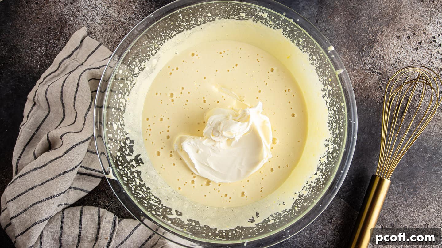 Adding mascarpone to cooked egg and sugar mixture.