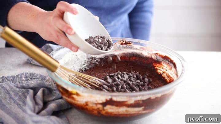 Adding chocolate chips to homemade brownies.