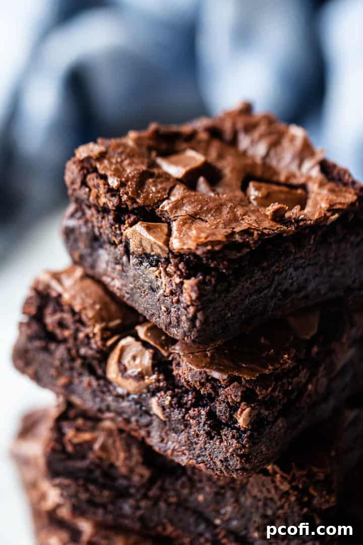Brownies from scratch, stacked tall and displayed against a cool blue background.