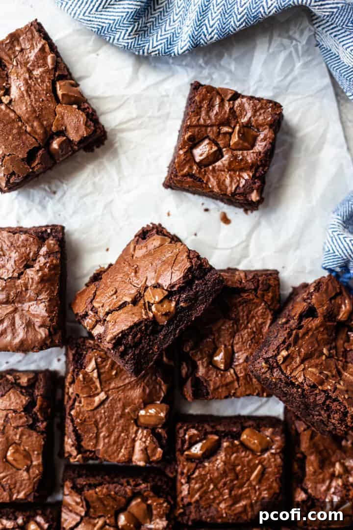 Best brownie recipe, prepared and cut into squares on a white background with a blue cloth.