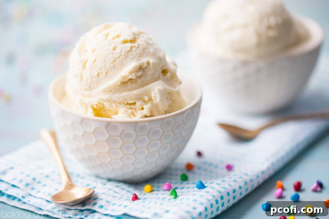 A scoop of homemade vanilla no-churn ice cream in a bowl, topped with a spoon. This easy recipe requires no ice cream machine.