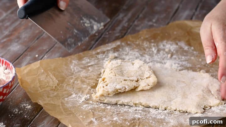 Folding pie dough into thirds, like a letter, to create multiple flaky layers during the lamination process.