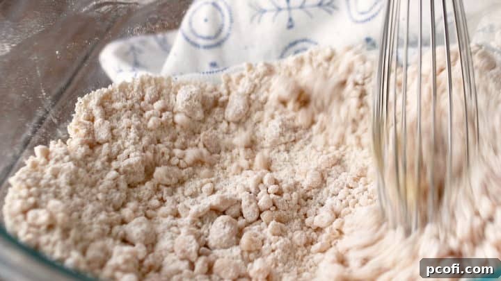 Stirring vegetable oil into flour and salt mixture to create a tender, crumbly pie crust base.