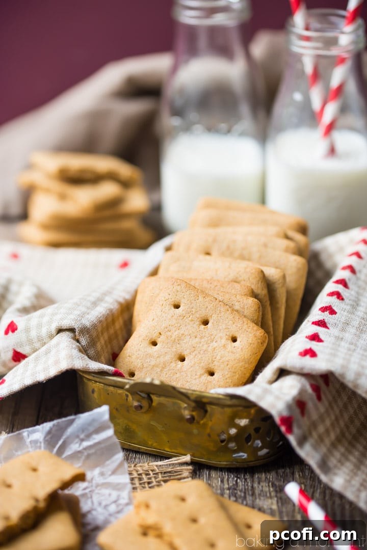 Close-up of freshly baked graham crackers cooling on a wire rack, highlighting their perfectly browned edges and uniform shape.