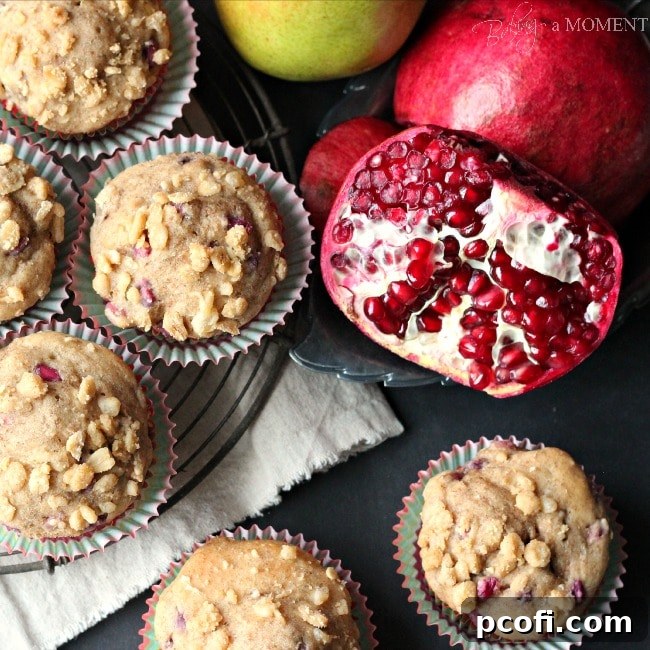 Golden brown pomegranate pear muffins cooling on a wire rack