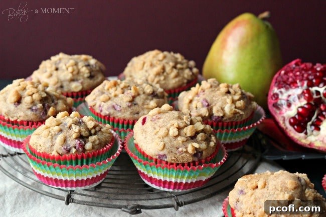 Freshly baked pomegranate pear muffins with a golden streusel topping ready to be enjoyed