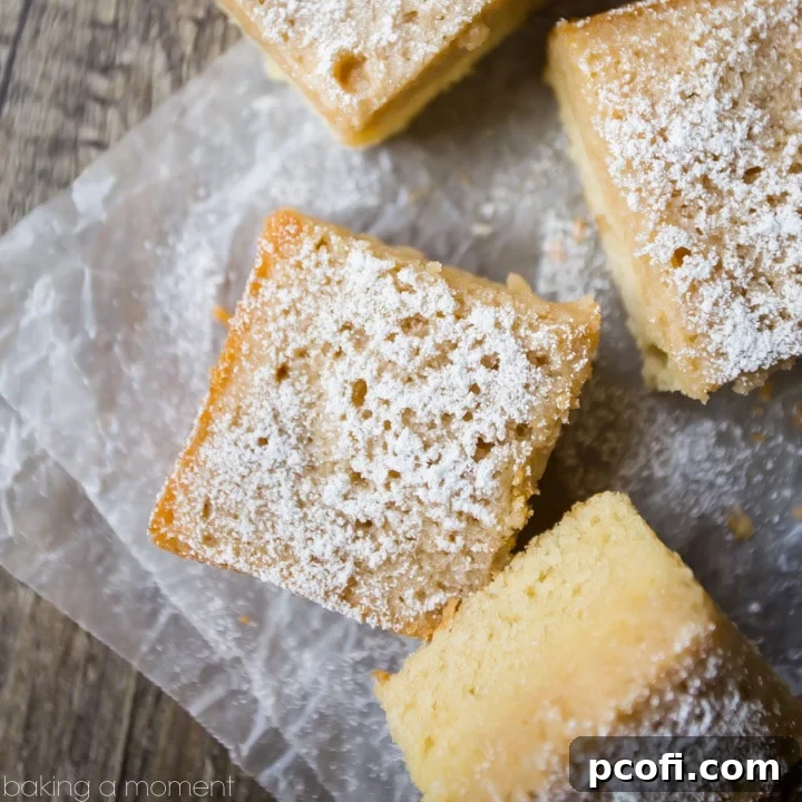 Rich, buttery Maple Gooey Butter Cake with a glistening, golden-brown gooey topping, fresh out of the oven, highlighting its irresistible texture.