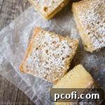 A top-down view of a single slice of Maple Gooey Butter Cake, adorned with powdered sugar, ready to eat.