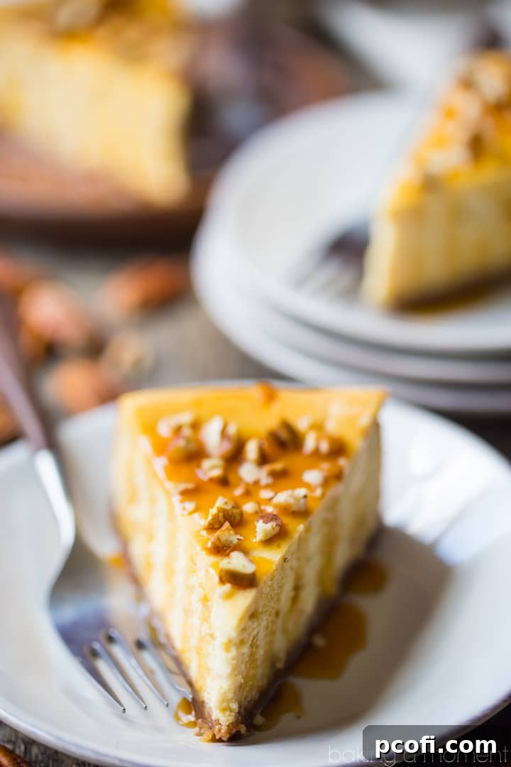 A stunning top-down view of a whole caramel pecan cheesecake, richly drizzled with caramel and adorned with chopped pecans, ready to be sliced and served. It highlights the creamy texture and inviting presentation.