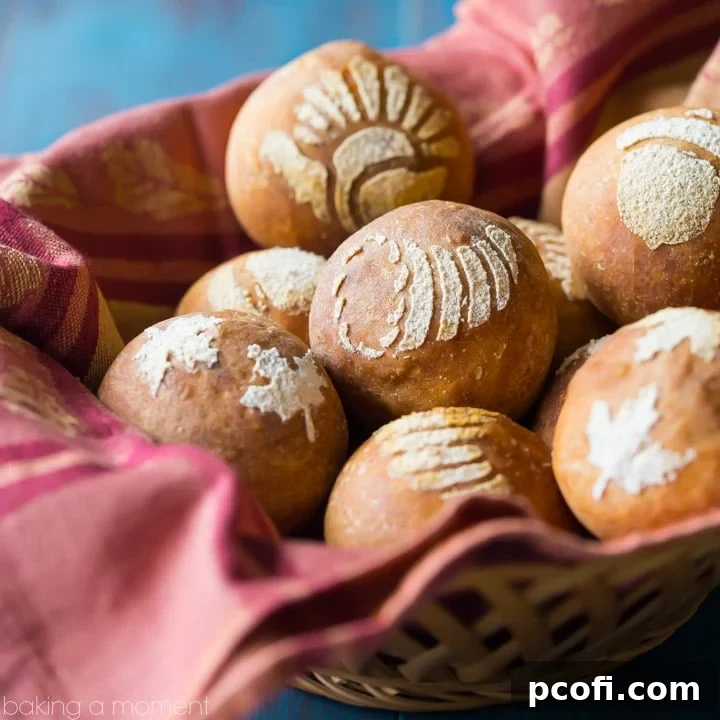 Basket lined with a red cloth, filled with bread rolls stenciled with fall/Thanksgiving themed images, on an aqua tabletop. food bread crafts
