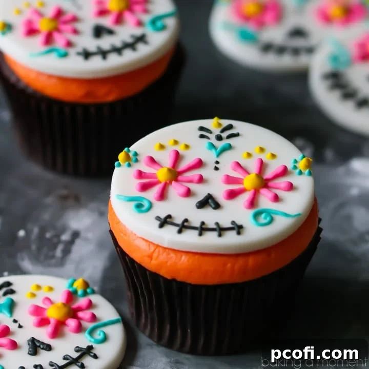 Colorful fondant Day of the Dead cupcake topper on a rich chocolate cupcake with bright orange frosting, perfect for Halloween.