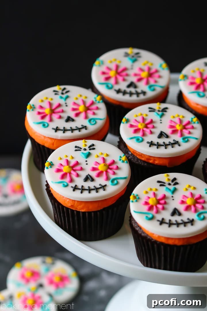Day of the Dead Cupcakes ready for a party, featuring colorful fondant toppers and bright orange frosting on delicious chocolate cupcakes. Perfect for festive celebrations.