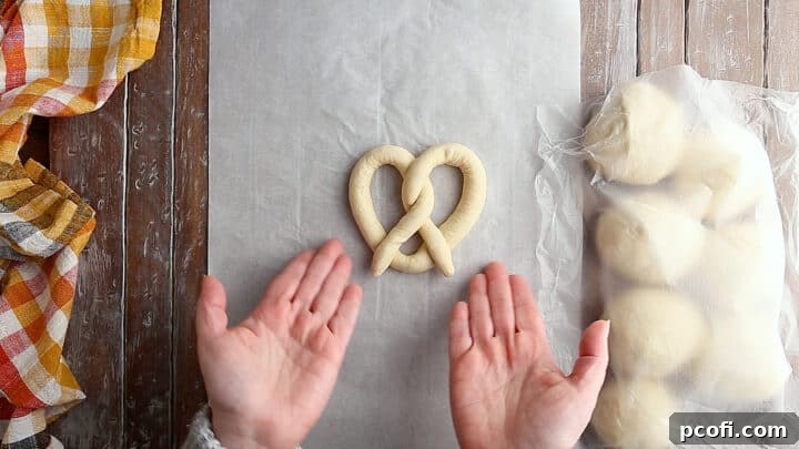A fully shaped, unbaked soft pretzel, showcasing the perfectly twisted dough before its final rise and bake.