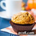 A batch of tall, puffy, and moist Pumpkin Muffins, perfect for a cozy fall morning.