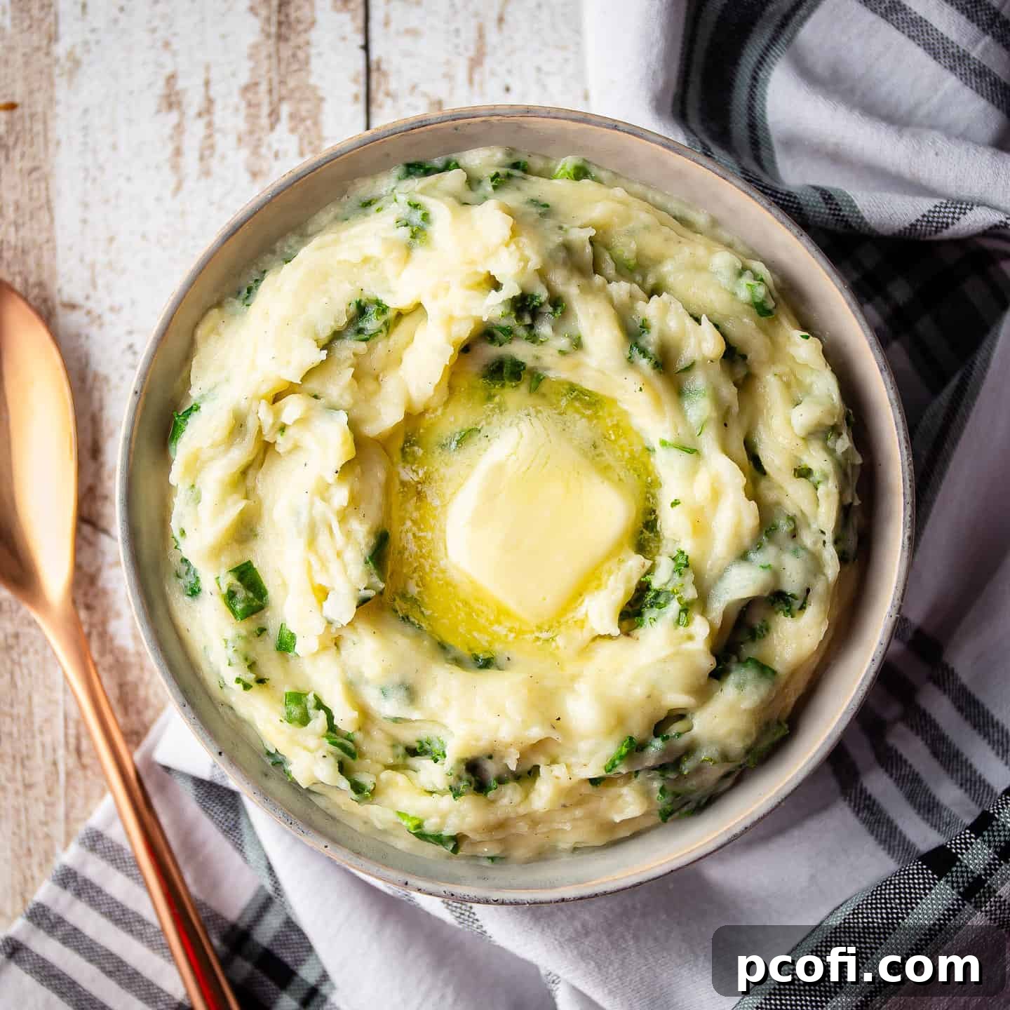 Creamy Irish Colcannon in a serving bowl, topped with melting butter, ready to be enjoyed as a comforting side dish.