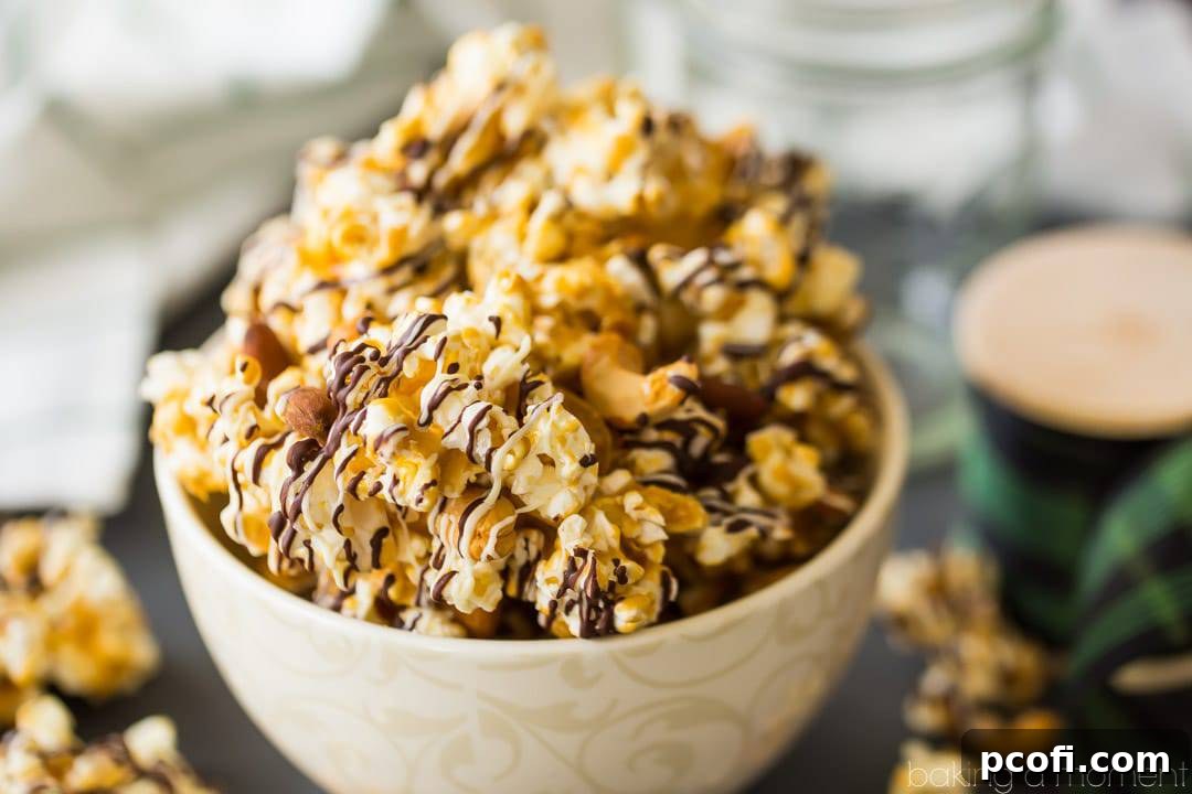 Homemade Moose Munch butter toffee caramel popcorn with nuts and chocolate drizzle, in a bowl with a spool of holiday ribbon in the background