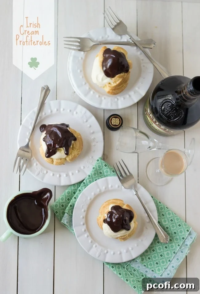 Close-up of fluffy Irish Cream Profiteroles with chocolate sauce, highlighting their creamy filling.
