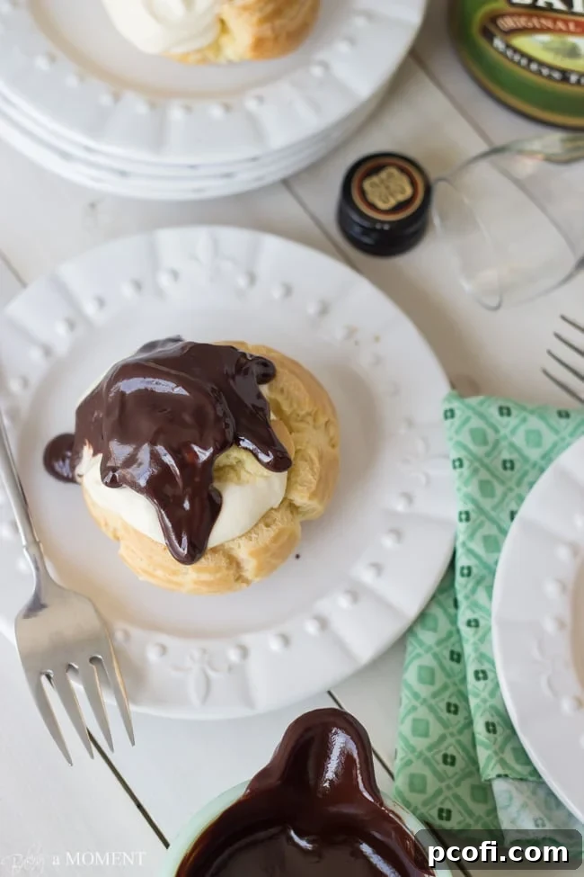 Irish Cream Profiteroles being drizzled with a rich, warm chocolate sauce.