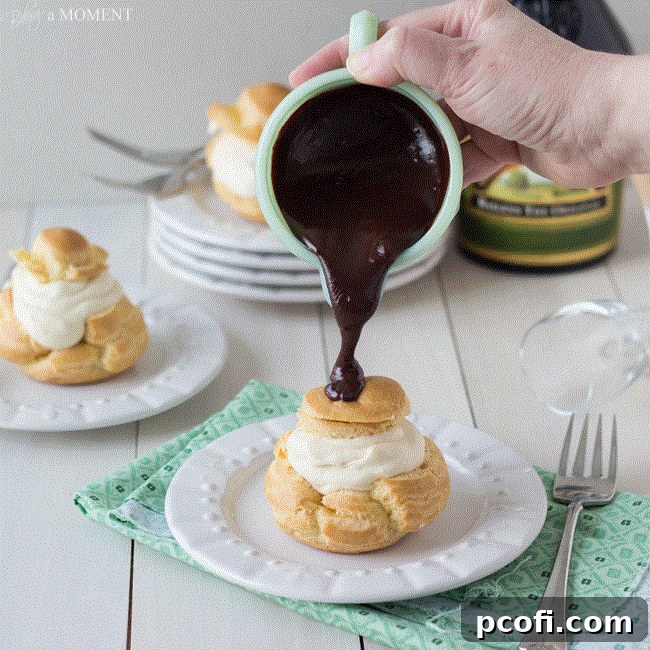 A beautifully presented Irish Cream Profiterole, topped with dark chocolate ganache, on a plate.