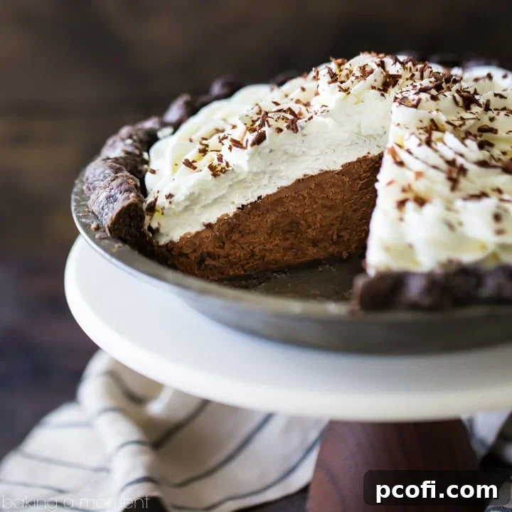 Chocolate Cream Pie with a flaky chocolate crust, piled high with fluffy chocolate mousse filling and topped with delicate chocolate shavings, a perfect no-bake dessert.