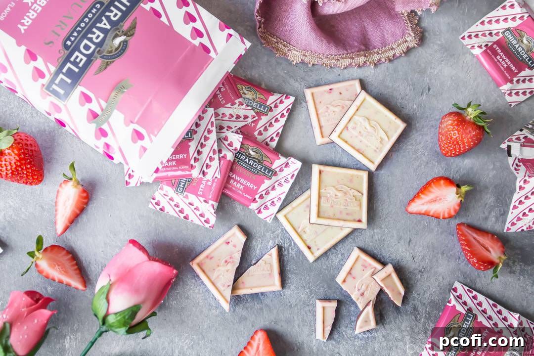 Ghirardelli Strawberry Bark SQUARES spilling gracefully from their bag, some unwrapped and broken, surrounded by fresh, ripe strawberries and delicate pink rosebuds, evoking a sense of sweet romance.